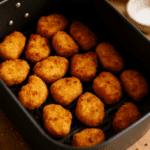 Chicken Nuggets während der Zubereitung in der Heißluftfritteuse, gleichmäßig verteilt im Garkorb