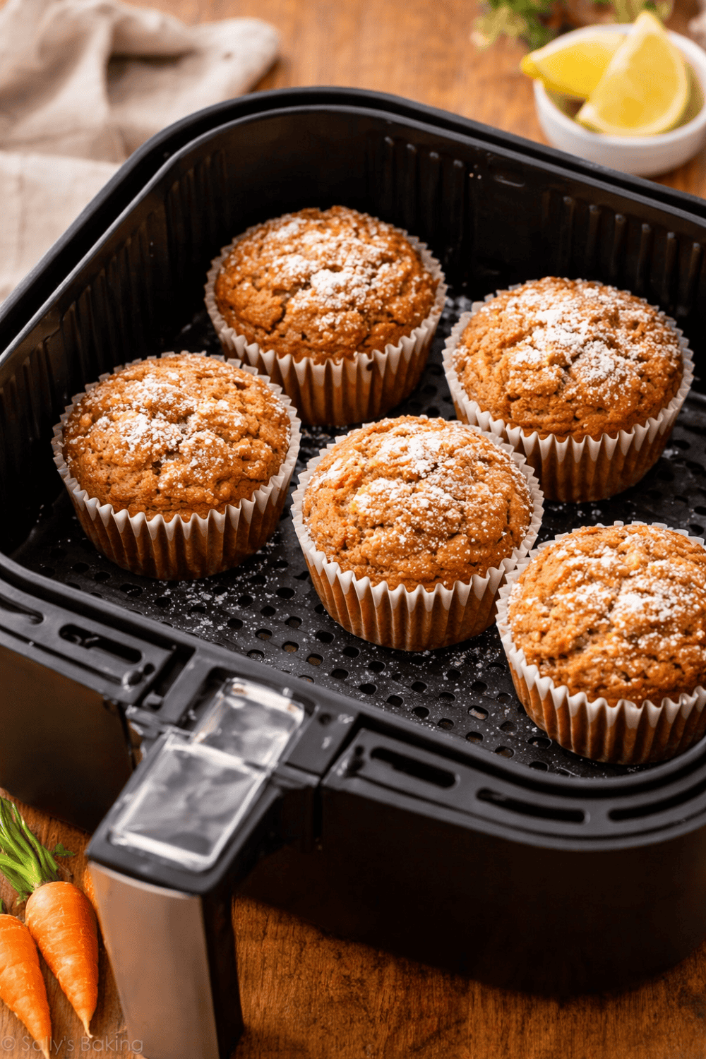 Frisch gebackene Karottenmuffins im Airfryer-Korb mit Puderzucker bestäubt, direkt aus der Heißluftfritteuse