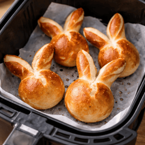 Laugen-Osterhasen auf Backpapier im Airfryer-Korb während des Backens