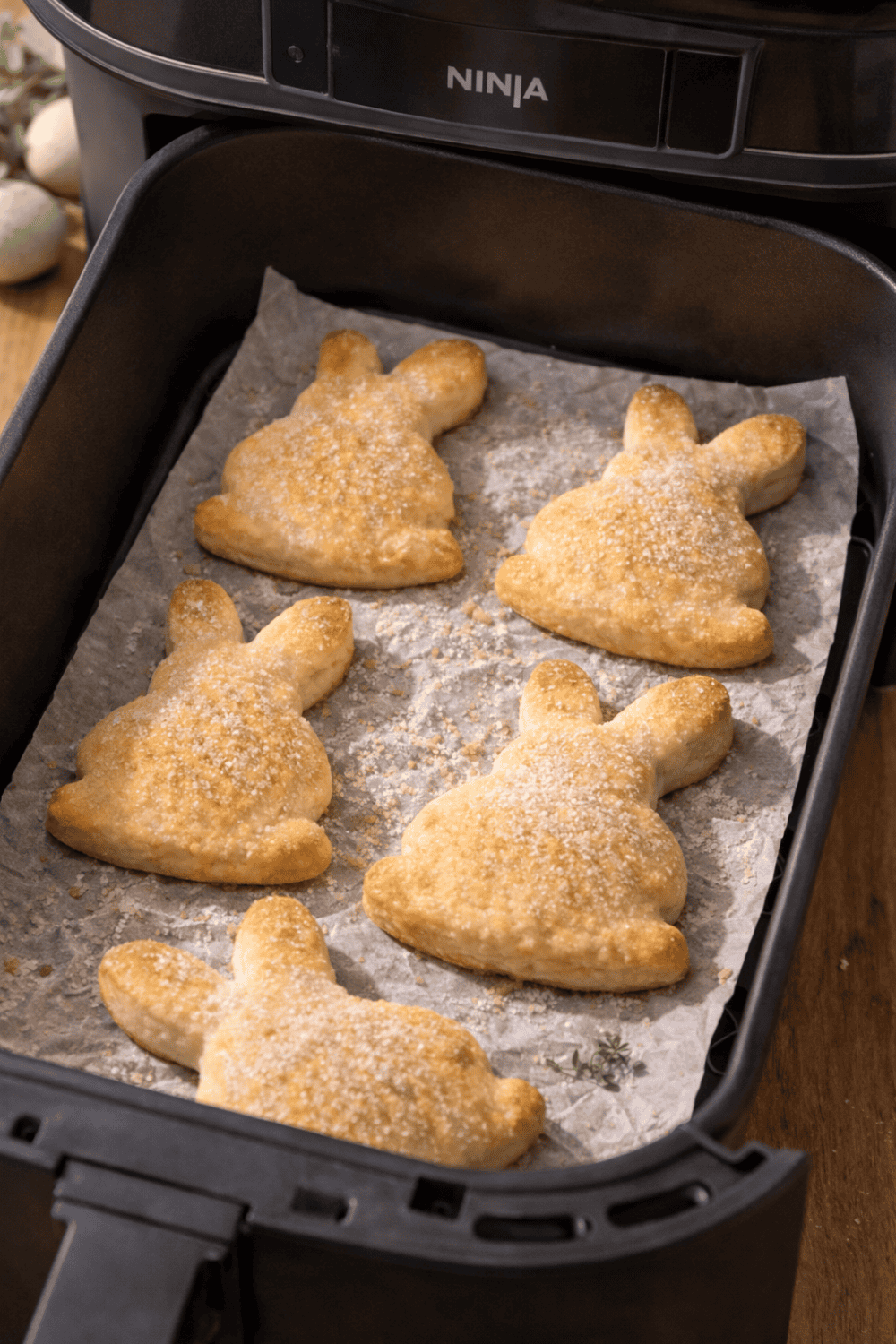 Osterhasen aus Quark-Öl-Teig im Ninja Airfryer Garkorb, mit Puderzucker bestreut, vor dem Backen