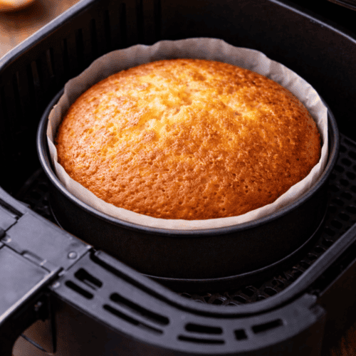 Frisch gebackener Zitronenkuchen in runder Backform direkt im Airfryer-Korb, perfekt gebräunt und aufgegangen