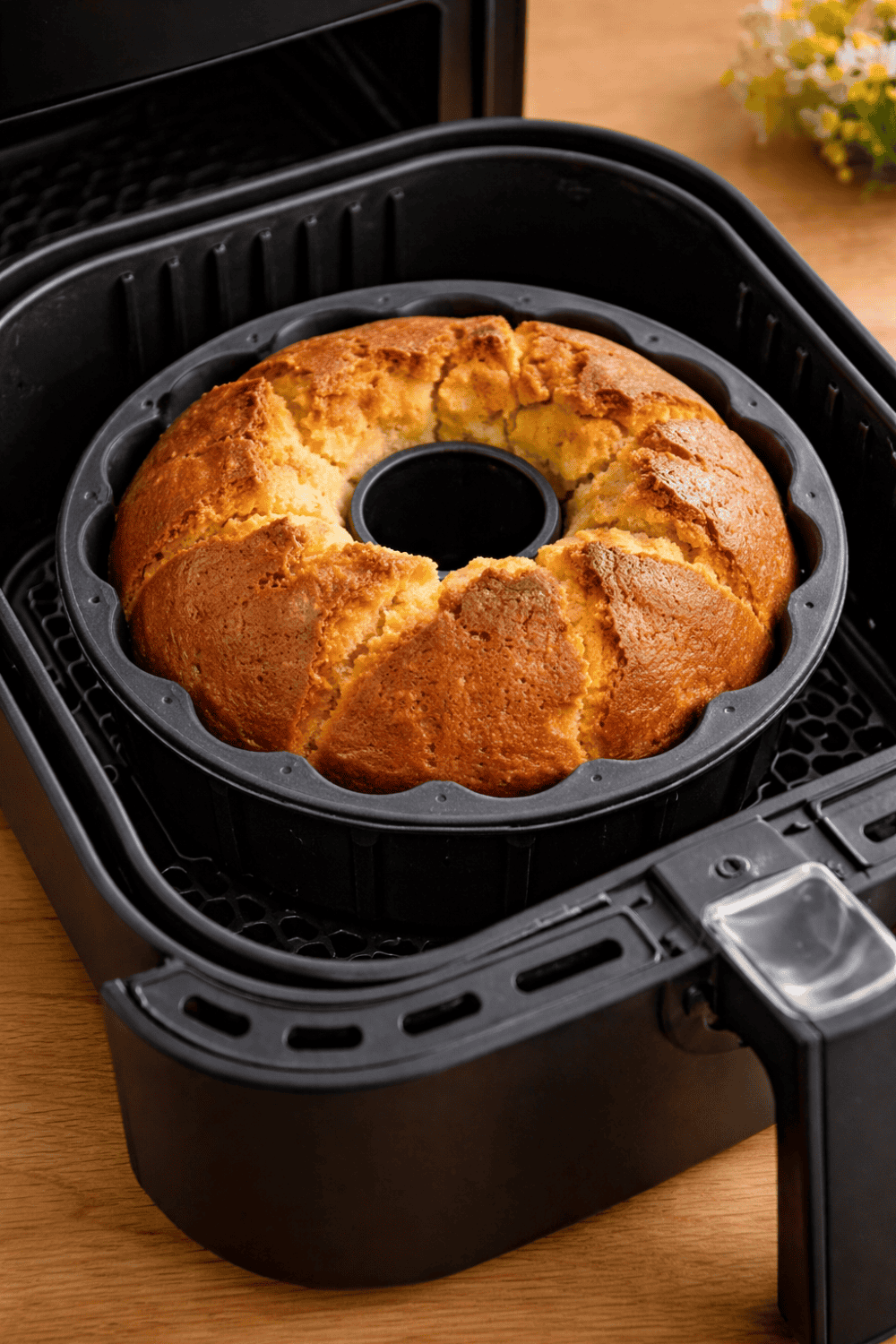 Frisch gebackener Gugelhupf mit Eierlikör in der Backform im Airfryer-Korb, goldbraun und fertig zum Stürzen