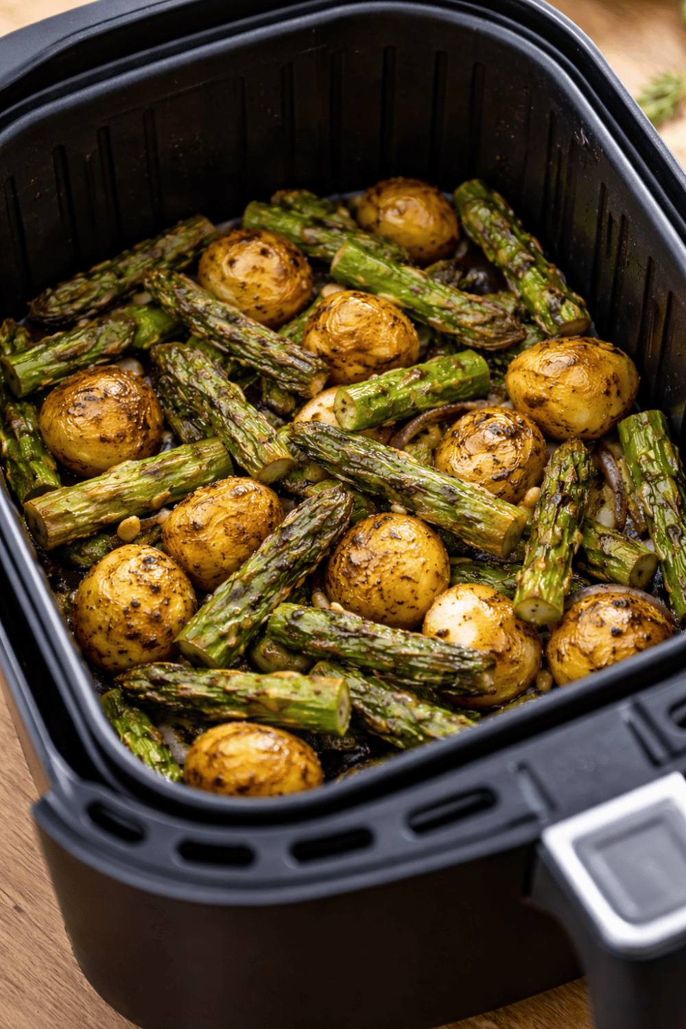 Spargel-Auflauf in kleiner Auflaufform im Airfryer-Korb, überbacken mit Käse, Kartoffeln und grünem Spargel sichtbar
