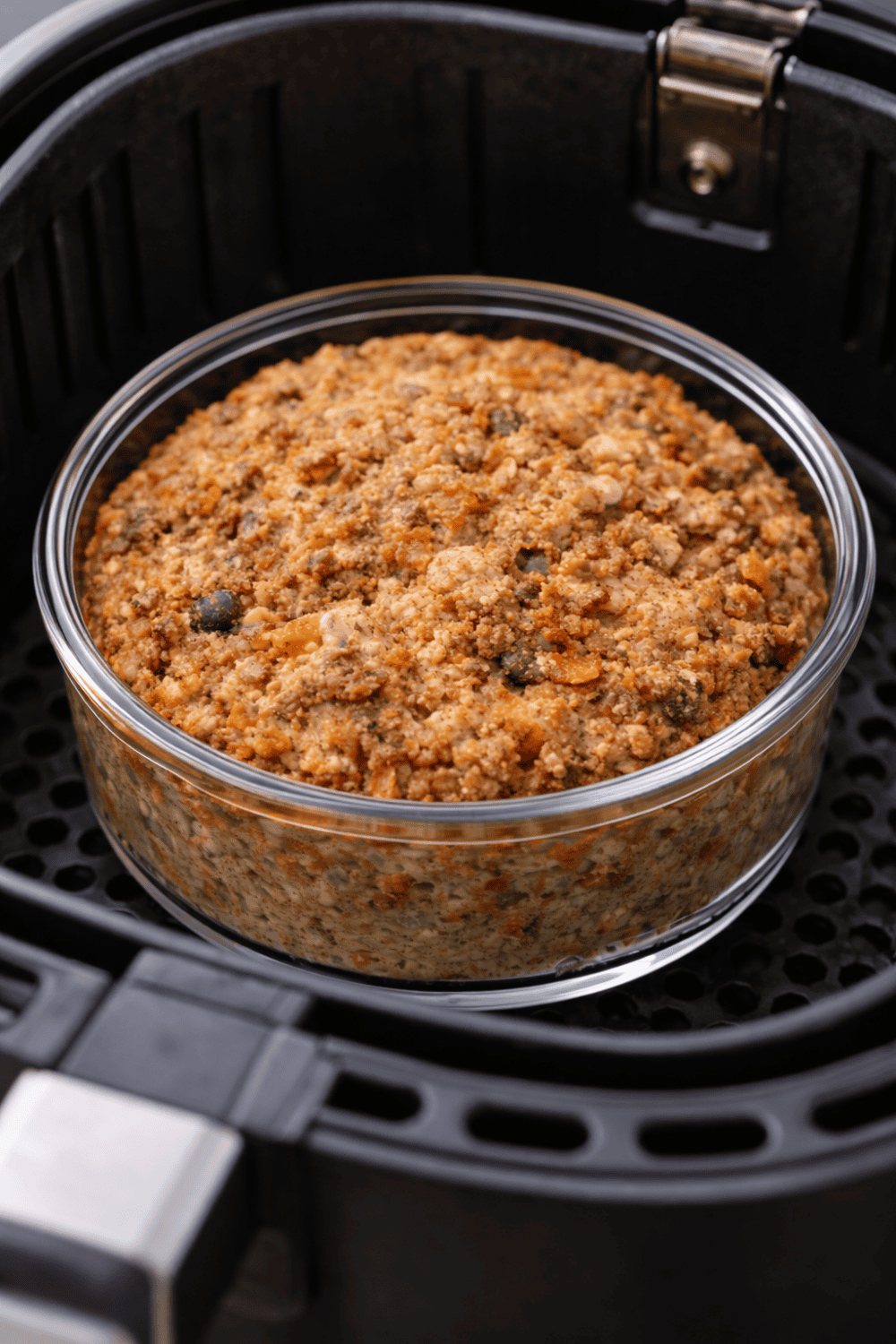 Baked Oats mit Karotte und Apfel in runder Glasform im Airfryer Korb, goldbraun gebacken mit sichtbaren Karottenstückchen