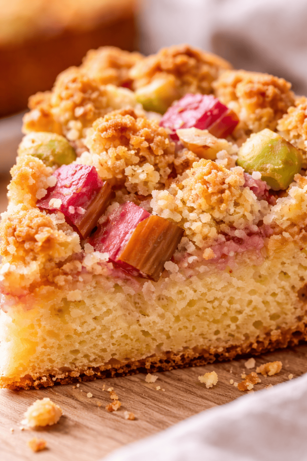 Angeschnittenes Stück Rhabarber-Streuselkuchen aus der Heißluftfritteuse – saftiger Rührteig mit fruchtigem Rhabarberbelag und goldbraunen Streuseln, Nahaufnahme.