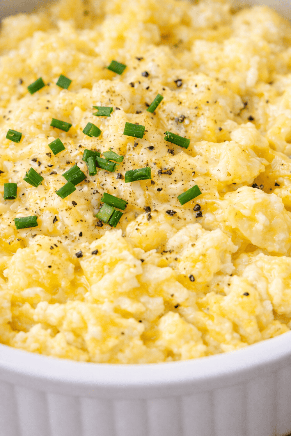 Nahaufnahme von cremigem Airfryer-Rührei mit frischem Schnittlauch und Pfeffer – perfekte Konsistenz