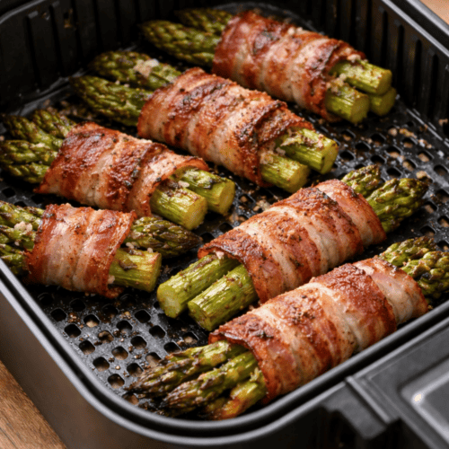 Grüner Spargel mit Bacon umwickelt im Airfryer-Korb beim Garen